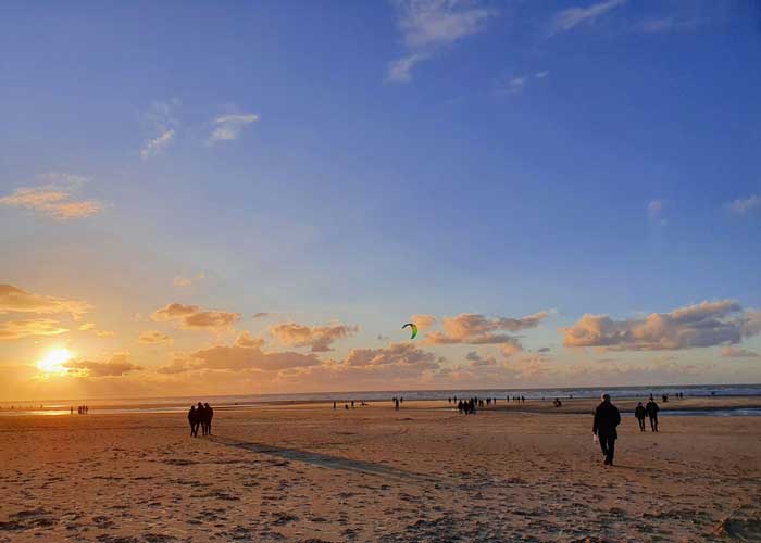 Promeneurs sur la plage du Touquet-Paris-Plage au coucher du soleil