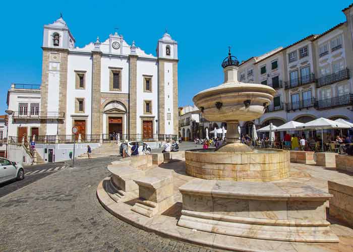 Fontaine de marbre et église de Santo Antão sur la place centrale d’Évora, en Alentejo