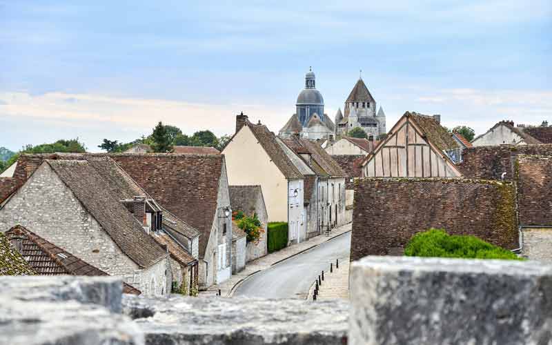 Vue pittoresque du village de Provins, avec en arrière-plan une église au dôme imposant, illustrant le charme authentique du 
							patrimoine français