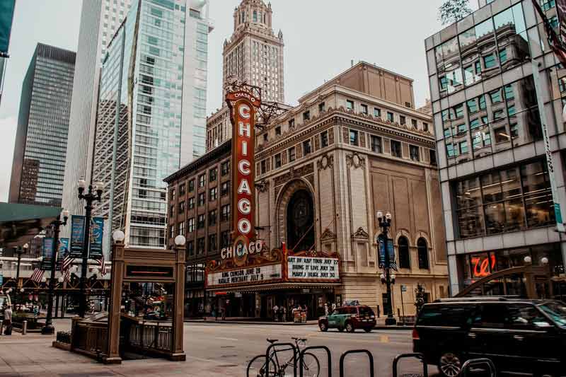 Vue du célèbre Chicago Theatre avec son enseigne lumineuse rouge, entouré de gratte-ciel modernes et de bâtiments historiques