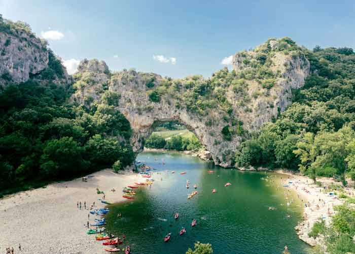 Kayakistes et baigneurs au pied du pont d'Arc, arche naturelle embl�matique enjambant l'Ard�che au d�part des gorges, Vallon-Pont-d'Arc, Ard�che