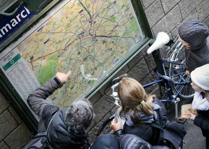 Touristes consultant un plan de Paris pour organiser une visite de Paris, avec v�los et carte des transports