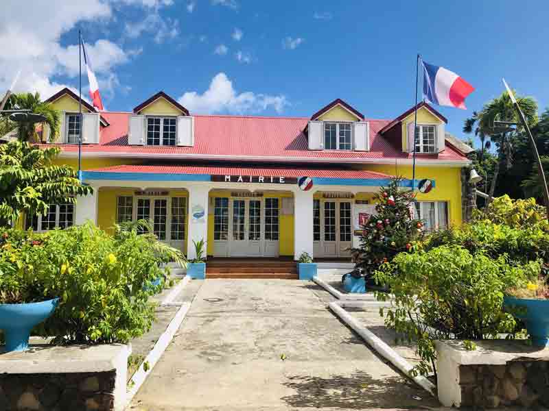 Mairie de Terre-de-Haut dans l’archipel des Saintes, façade créole typique avec drapeaux français (Guadeloupe)