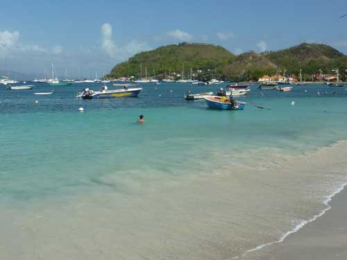 Plage animée de Terre-de-Haut aux Saintes avec barques et voiliers au mouillage (Guadeloupe)