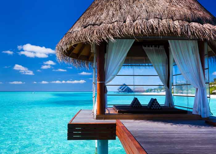Bungalow sur pilotis à Bora Bora avec vue sur le lagon turquoise et le mont Otemanu, sous un ciel bleu éclatant