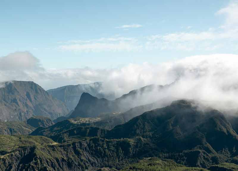 Vue sur le cirque de Mafate à La Réunion depuis le sentier du Cap Noir, enveloppé de brume matinale