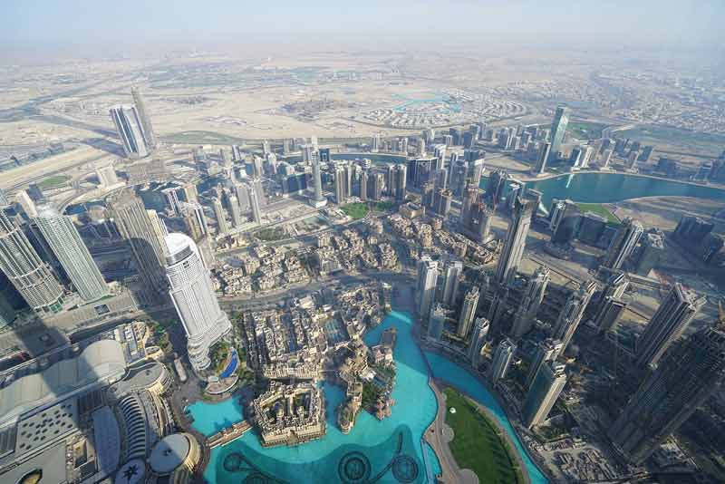 Vue aérienne de Dubaï avec ses gratte-ciel modernes, la célèbre fontaine de Dubaï et le désert s'étendant à l'horizon