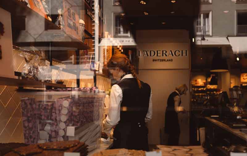 Boutique de chocolat Läderach à Genève avec vendeuse et spécialités suisses en vitrine