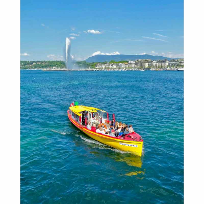 Bateau mouette jaune sur le lac Léman à Genève avec passagers à bord et Jet d’eau en arrière-plan, une activité Genève pour découvrir la ville autrement
