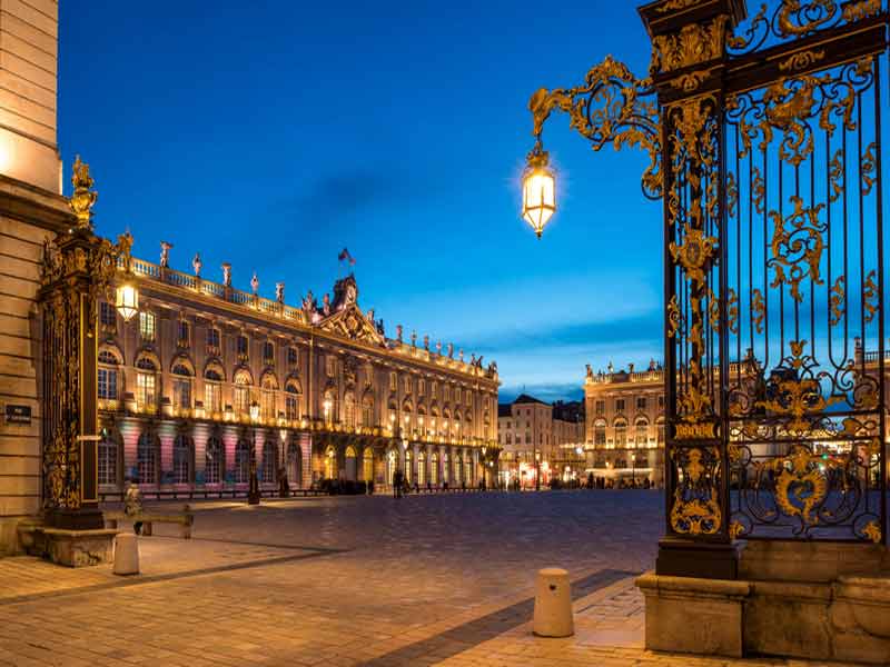 Place Stanislas à Nancy illuminée au crépuscule avec ses grilles dorées et ses bâtiments classés à l’UNESCO