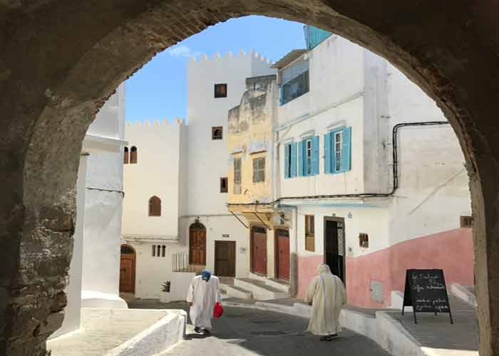 Vieille ruelle pittoresque de la mdina de Tanger, encadre par 
							une arche en pierre, avec des faades blanchies et des volets bleus